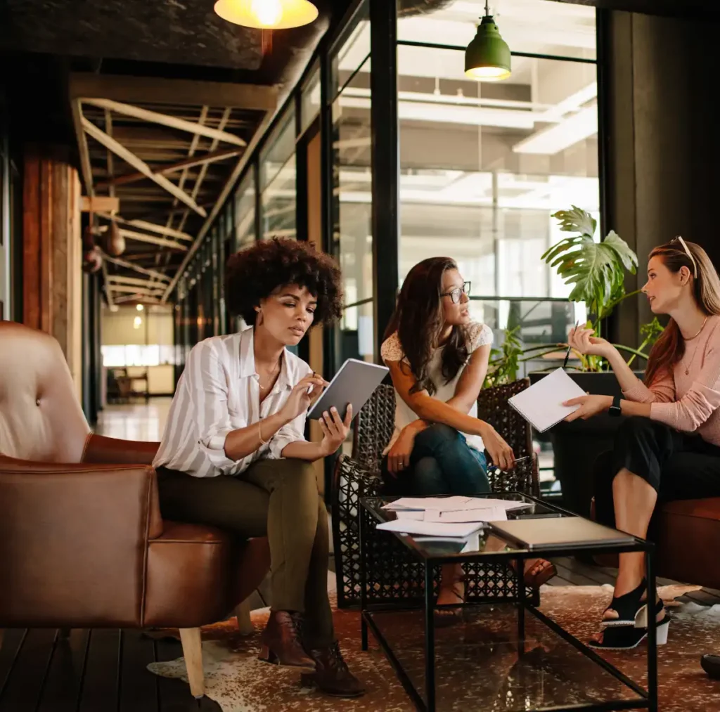 GGPA-careers A diverse group engaged in deep conversation in a modern office space, reflecting the inclusive and affirming therapy approach at Grazel Garcia Psychotherapy and Associates.
