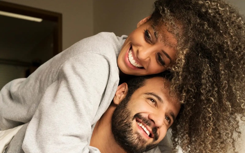 Loving-conversation-interracial-couples An interracial couple playfully wrestling on a bed