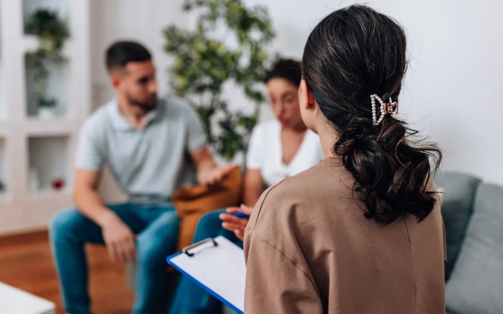 Healthy-communication-in-couples-counseling A couple on a therapist's couch having a polite, respectful discussion, representing the importance of healthy communication in couples counseling