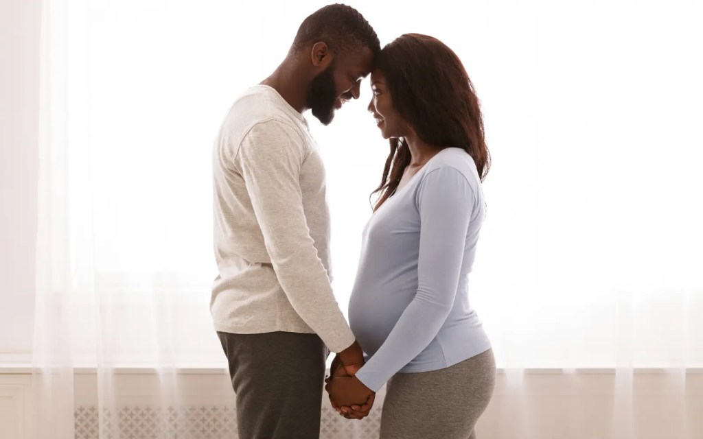 A neurodiverse black couple holding hands and looking into each others' eyes, representing the emotional bonding of neurodiverse couples counseling