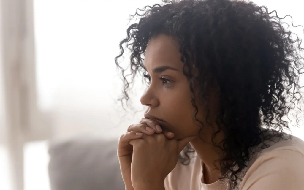 A woman pensively looking into the distance, representing the question Is EFT right for you?