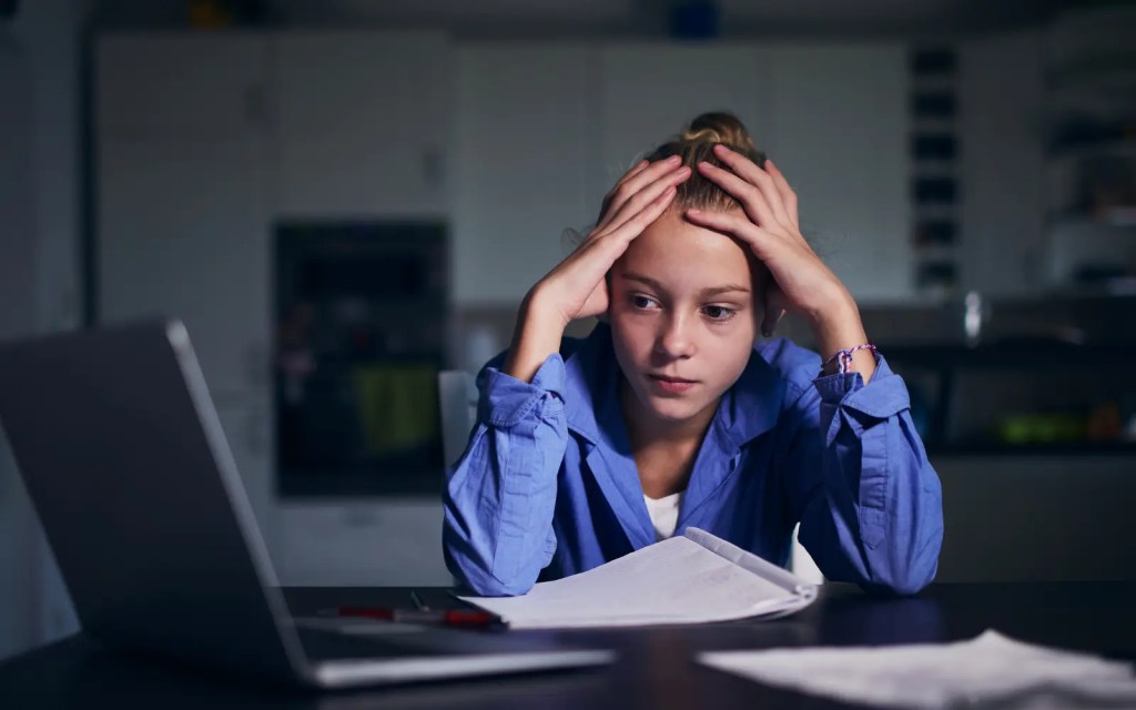 Neuropsychological-testing-for-children-in-Los-Angeles A child staring at a computer with her head in her hands, representing the importance of neuropsychological assessments for children in Los Angeles to help them succeed academically.