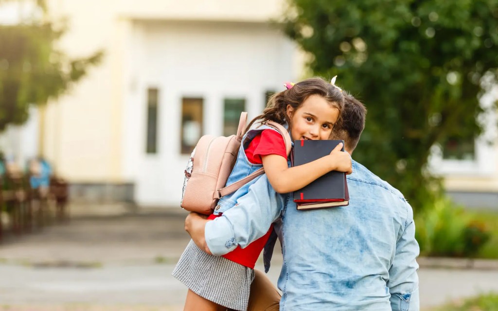 A father picking up his child from school, representing an appropriate time to park big emotions and return to them later
