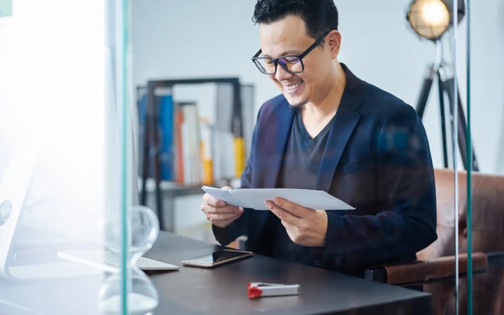 Receiving-neuropsychological-testing-results-in-LA A man smiling as he opens and reads his neuropsychological testing results