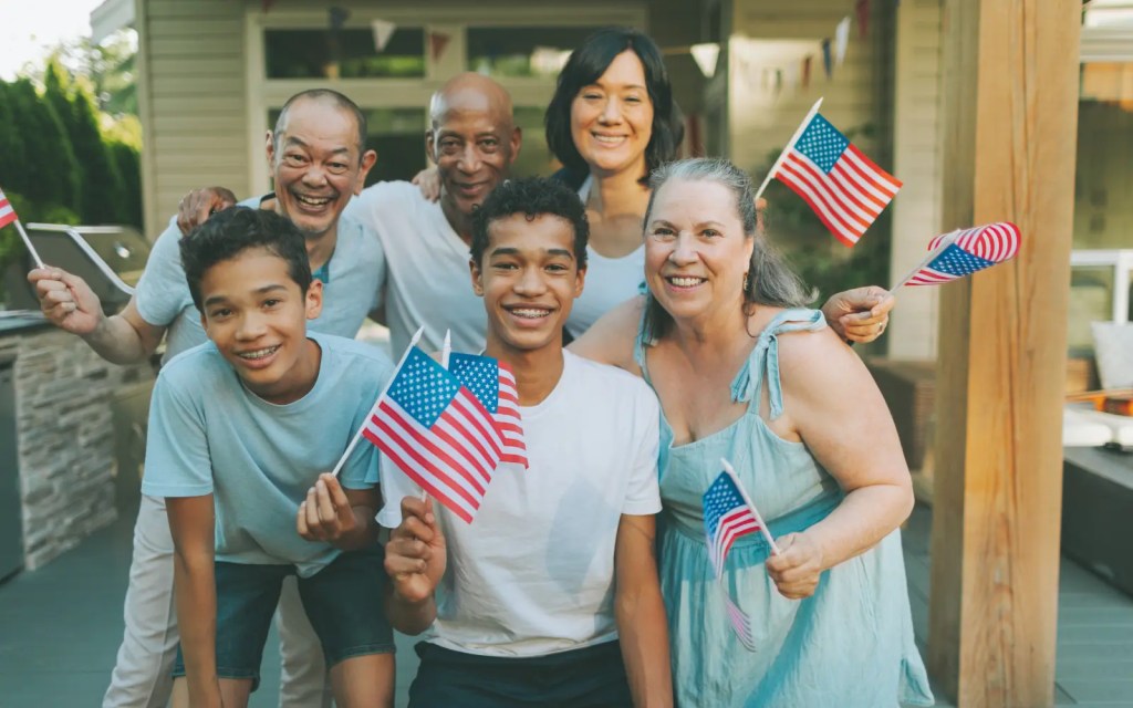 Asian-americans-and-neurodiversity A group of Asian Americans smiling and holding American flags, representing neurodiversity in Asian communities