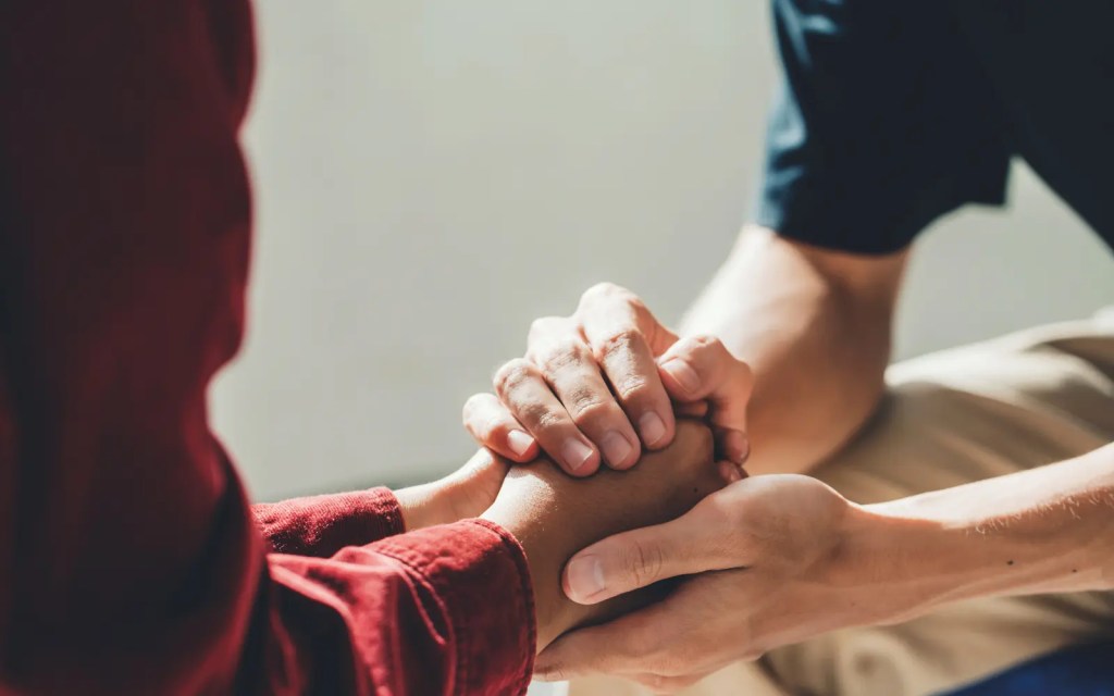 Couples-therapy-success A couple holding hands in couples therapy, representing success in their treatment