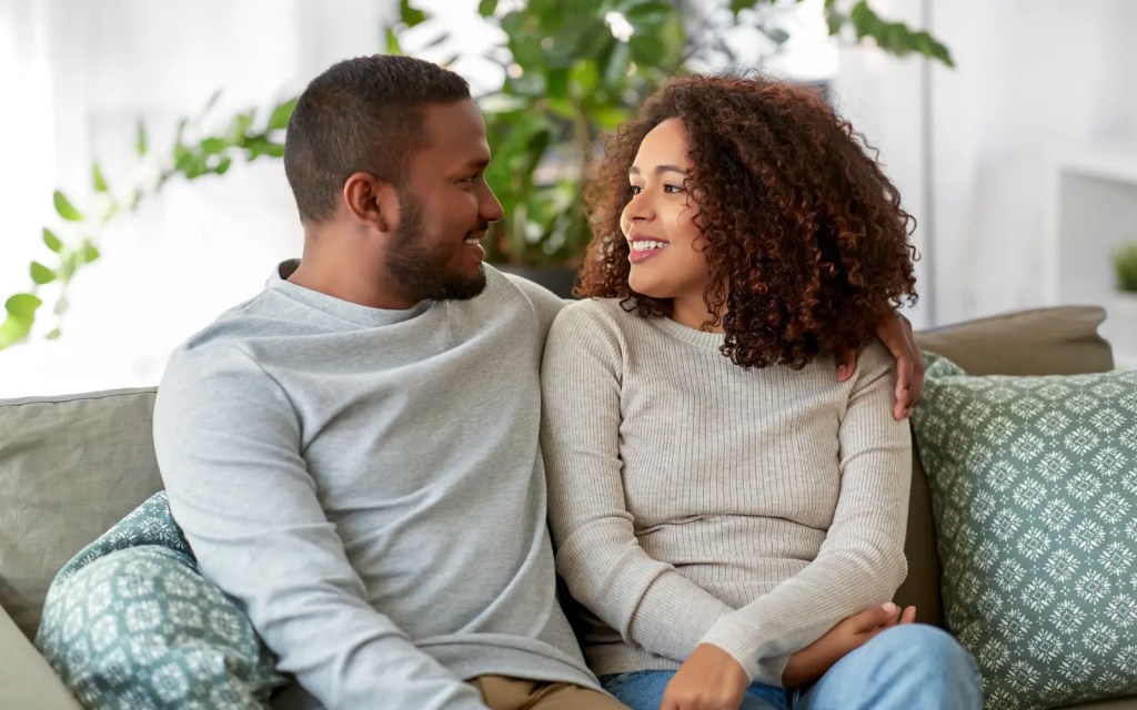 A couple having an intimate conversation cuddling on a couch during a temporary break from therapy.
