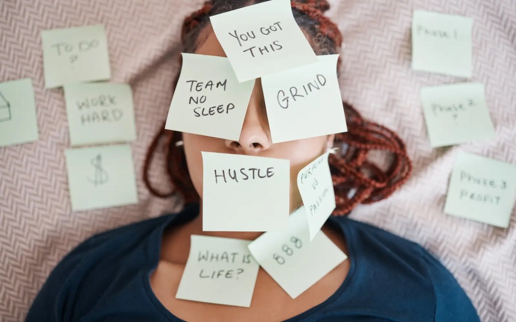 A woman with lots of postits stuck to her face, representing the amount of work an ADHDer has to put in to feel "caught up" in life