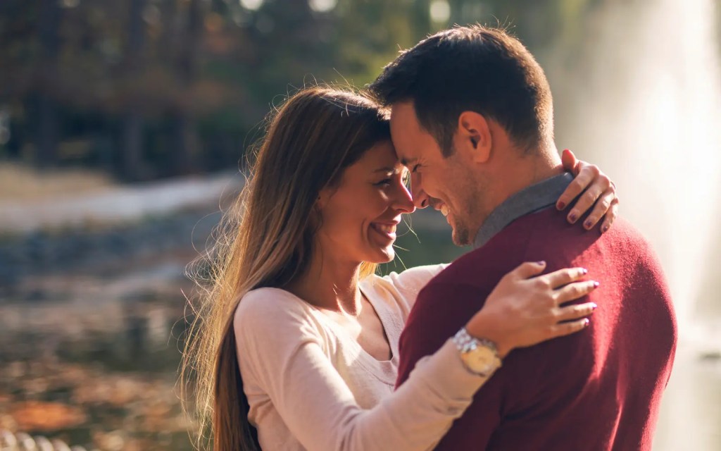 A couple embracing outdoors, representing emotional repair that's possible through ADHD couples therapy